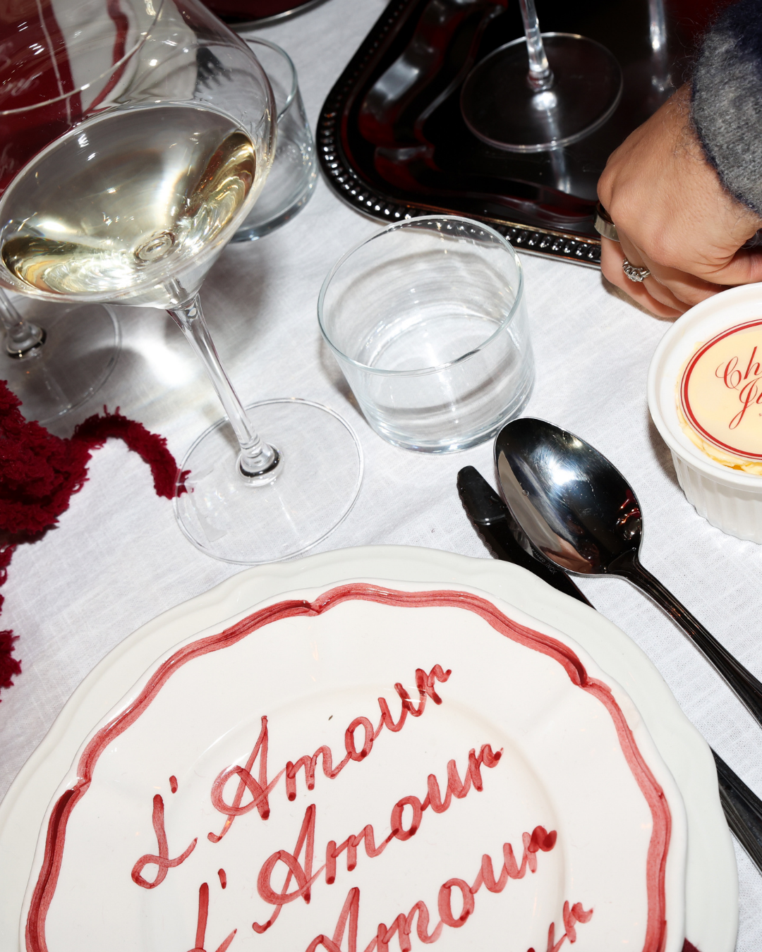 Chez Jules tablescape close-up – L’Amour plate, wine glasses and romantic red dinner details by Imaginary Friends.